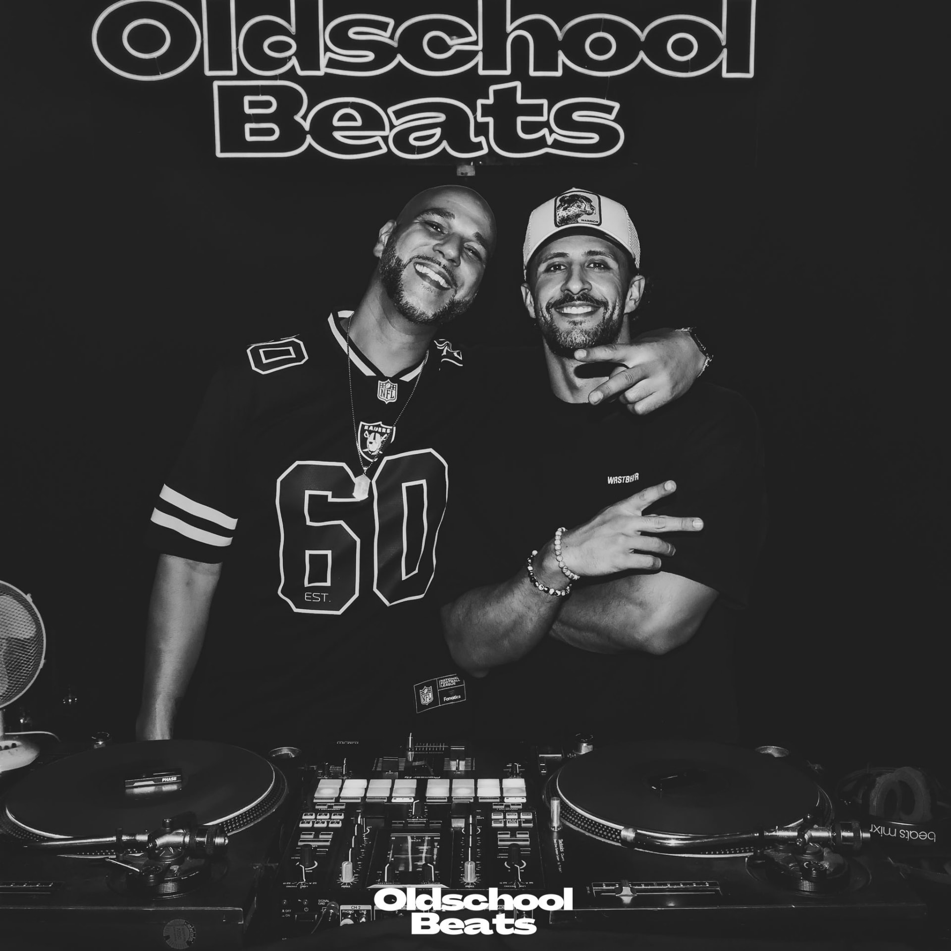 DJ Fareezy und DJ Big Lary hinter einem DJ-Pult mit Plattenspielern vor dem leuchtenden Oldschool Beats Schriftzug
